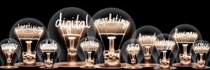 Photo d'ampoules avec des fibres brillantes en forme de mots liés au concept de marketing numérique, de site Web, de référencement et de stratégie isolés sur fond noir