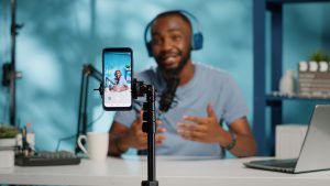 Close up of blogger filming video with smartphone on tripod