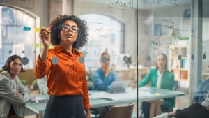Une jeune femme noire explique son plan de croissance des ventes à une équipe diversifiée