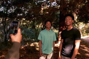 Jeunes frères et sœurs noirs adolescents prenant un selfie dans la nature ensemble en train de jouer