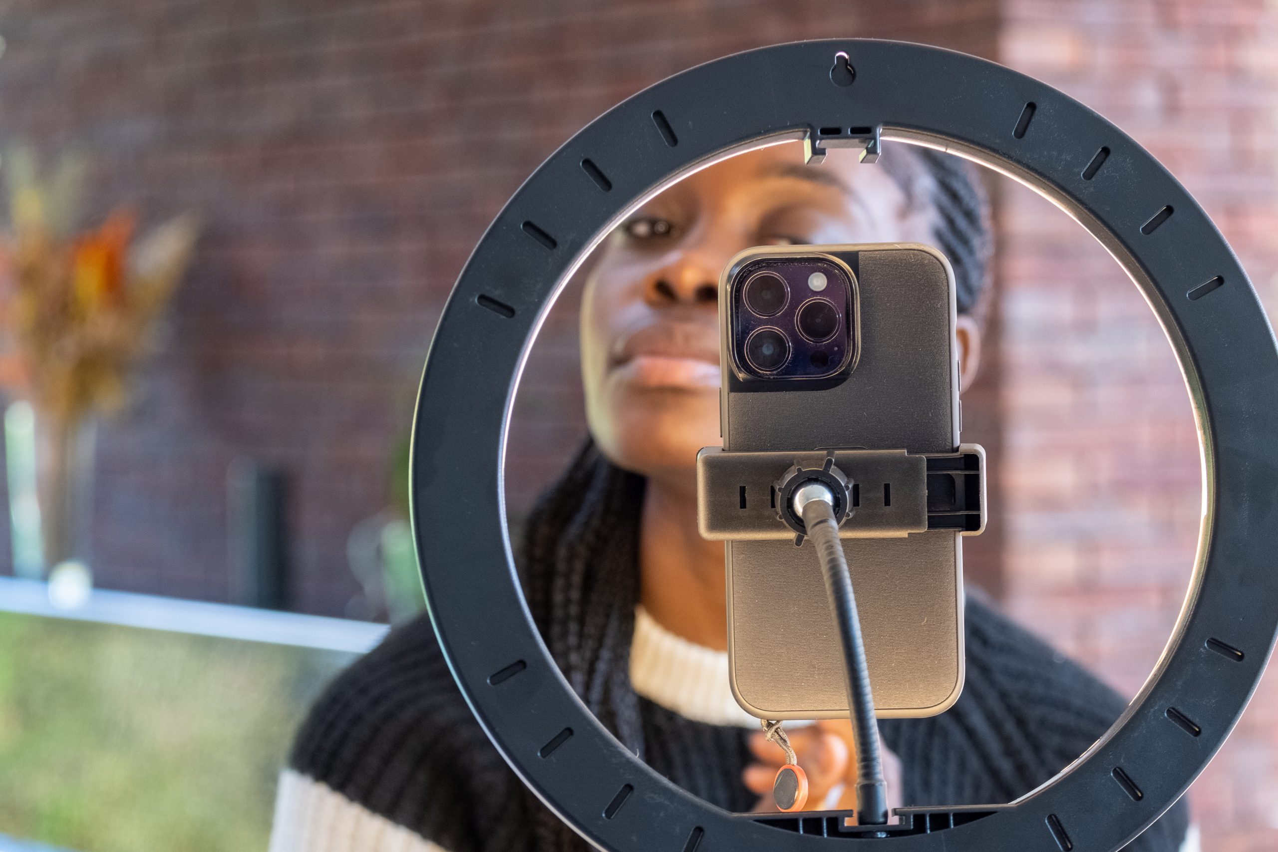 happy young african american woman streaming a beauty vlog from home, online content creator applying a makeup on