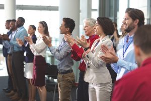 Des hommes d'affaires heureux applaudissent lors d'un séminaire d'affaires