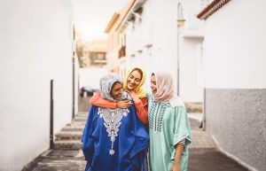 Femmes musulmanes heureuses marchant dans le centre-ville - jeunes filles arabes s'amusant à passer du temps et à rire ensemble en plein air - concept de style de vie, de culture et de religion