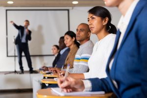 Une femme entrepreneure hispanique assise dans une salle de conférence lors d'un événement commercial