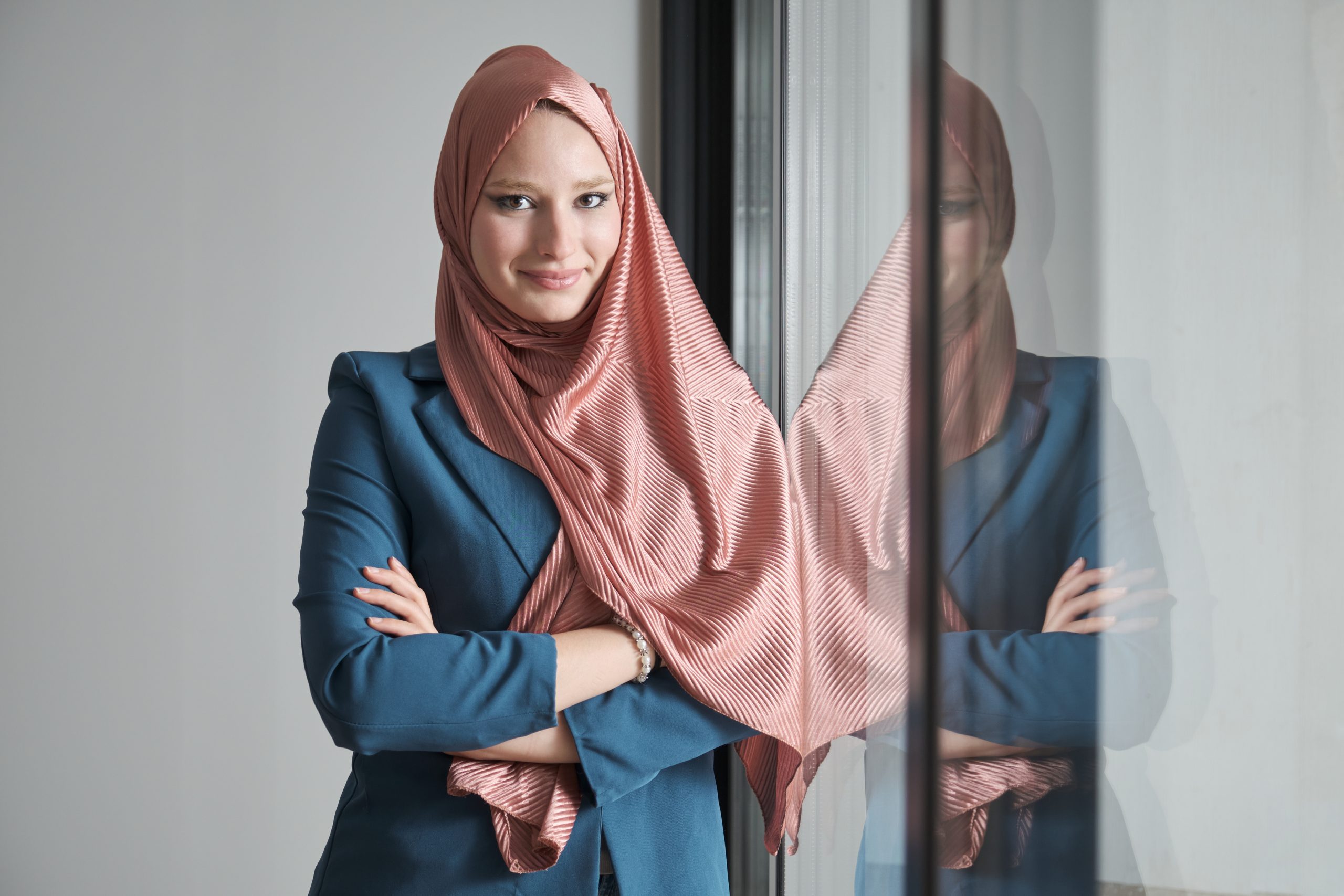 Portrait of young muslim businesswoman wearing hijab in office near by a window.