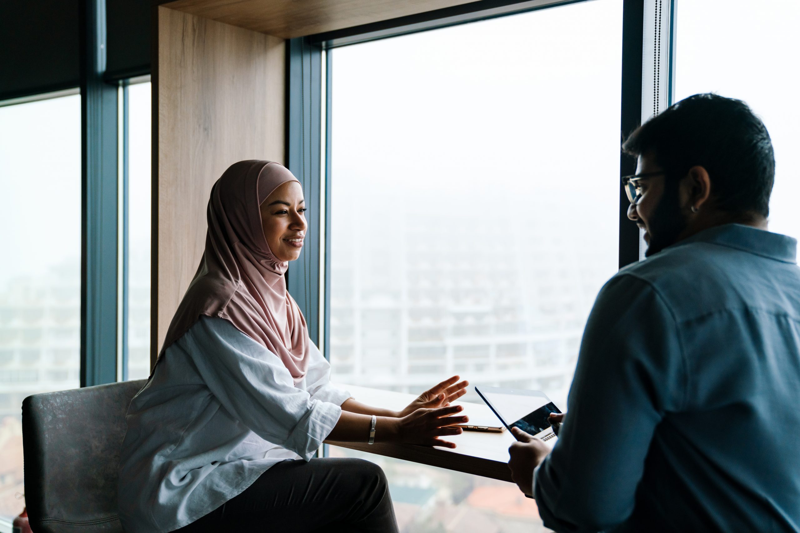 Two coworkers discussing project during business meeting in office